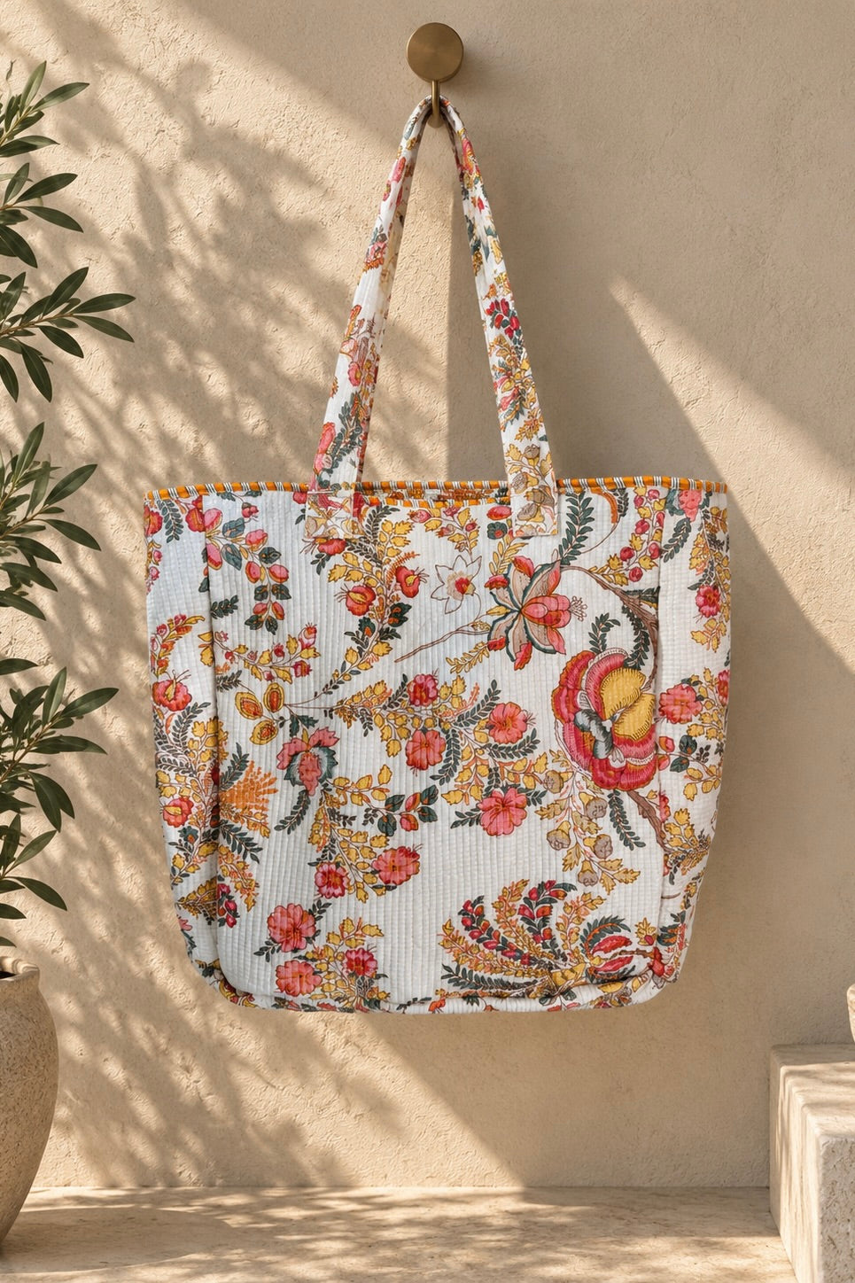Oversized white quilted floral jumbo tote bag with colorful pink, green and yellow botanical print and double shoulder straps.