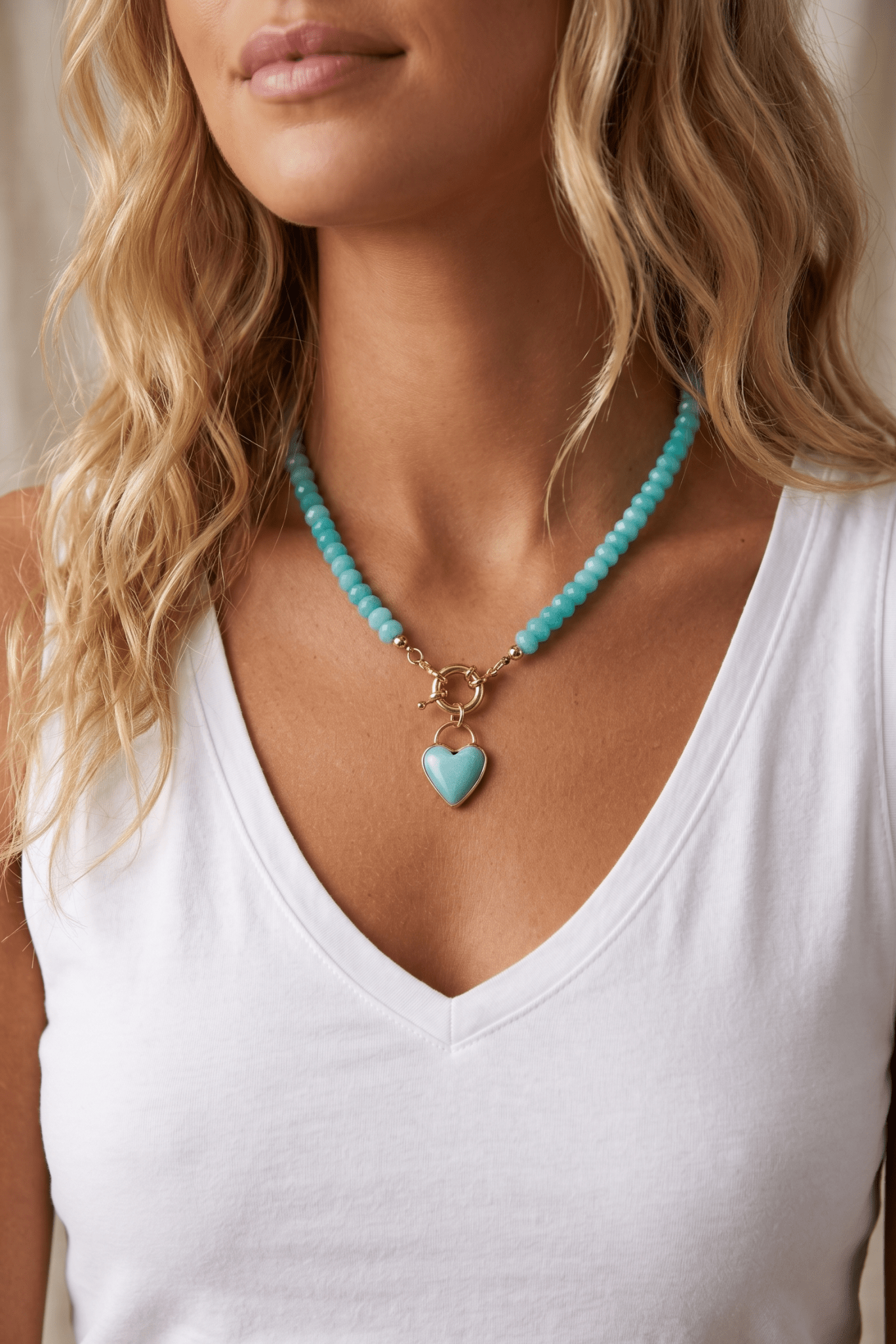 Turquoise bead necklace with heart pendant and gold clasp, cute summer necklace for vacation outfits, beach style, resort wear, poolside looks, and colorful warm weather accessories Sand + Charcoal