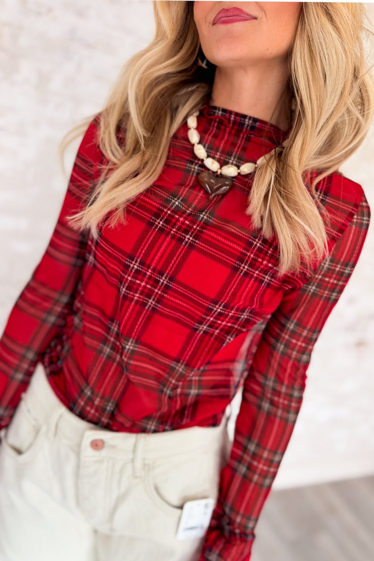 Women’s red plaid semi-sheer mesh long sleeve top featuring a fitted silhouette, high neckline, black and tan check pattern, and delicate frilled merrow lettuce-edge trim at the neckline, cuffs, and hem.