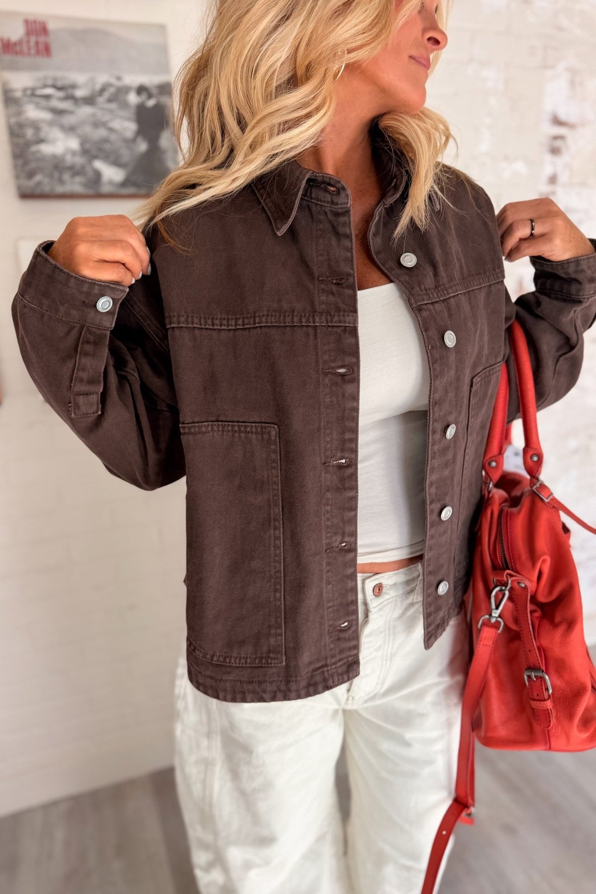 Women’s chocolate brown denim jacket featuring a relaxed boxy fit, collared neckline, silver button-front closure, long sleeves, dropped shoulders and oversized front patch pockets. A versatile brown denim layering jacket with a vintage-inspired washed look for casual fall outfits, everyday wear and transitional styling.