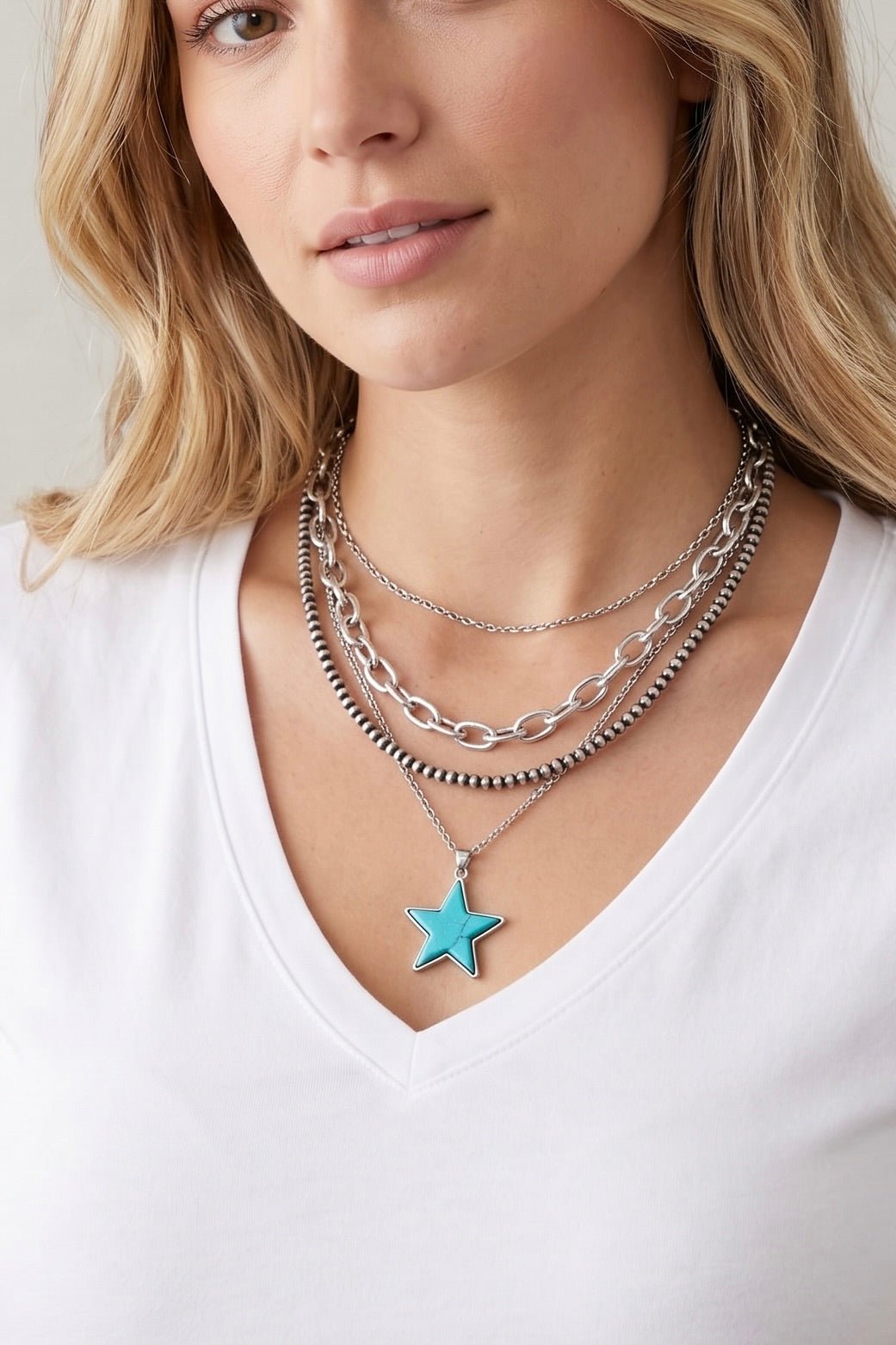 Three-strand western necklace featuring silver Navajo-inspired beads, layered cable chains, and a turquoise star pendant with an antique silver finish.
