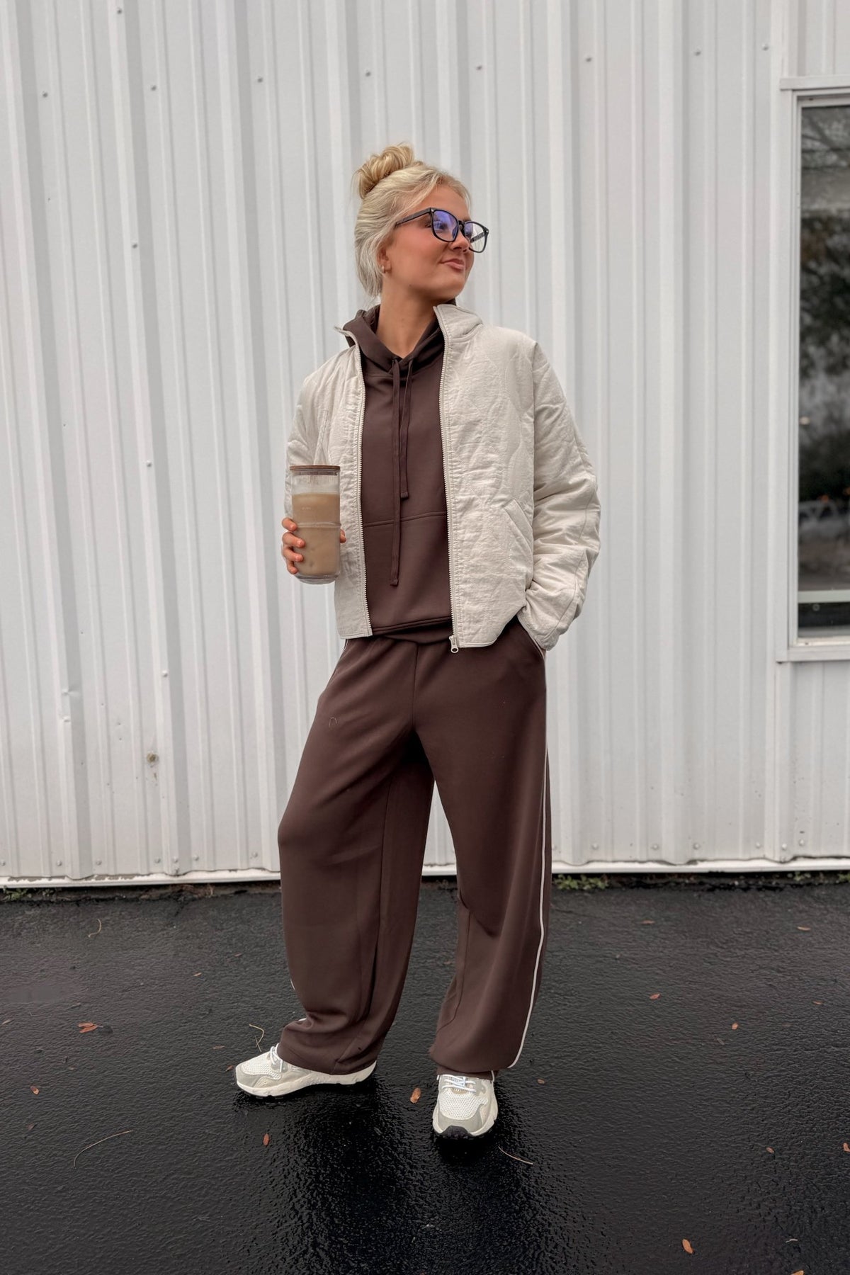 Women’s chocolate brown pullover hoodie featuring a relaxed oversized fit, drawstring hood, dropped shoulders, long sleeves, front kangaroo pocket, and contrast ivory piping detail along the pocket and sides. Coordinating chocolate brown wide-leg sweatpants are available separately for a matching lounge set.