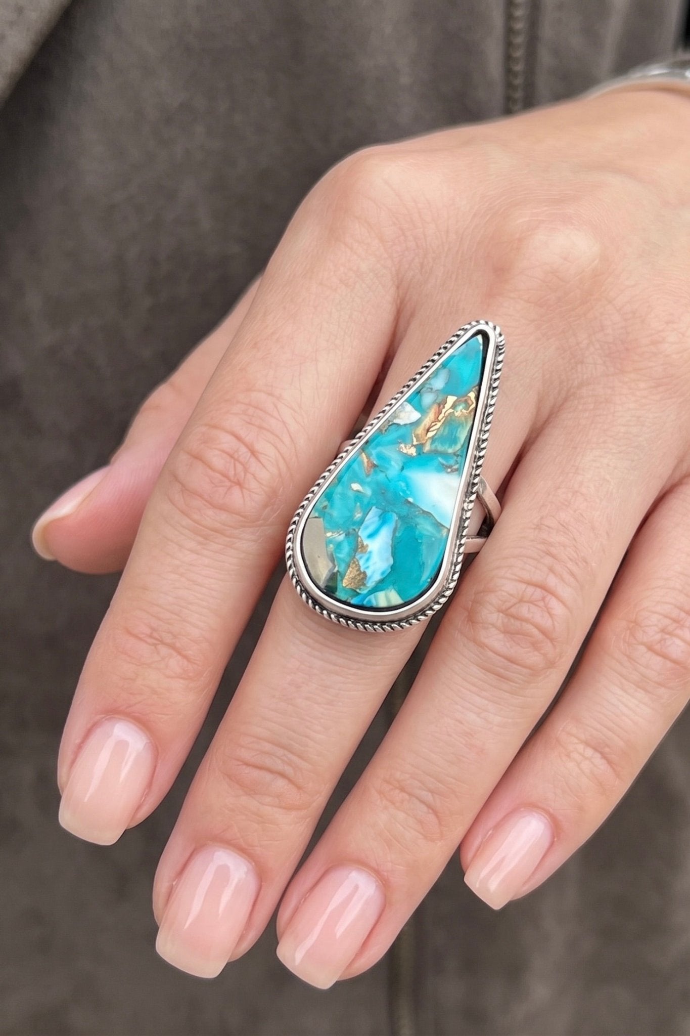 Oversized teardrop natural turquoise gemstone statement ring with an adjustable dual brass band and antique silver setting.
