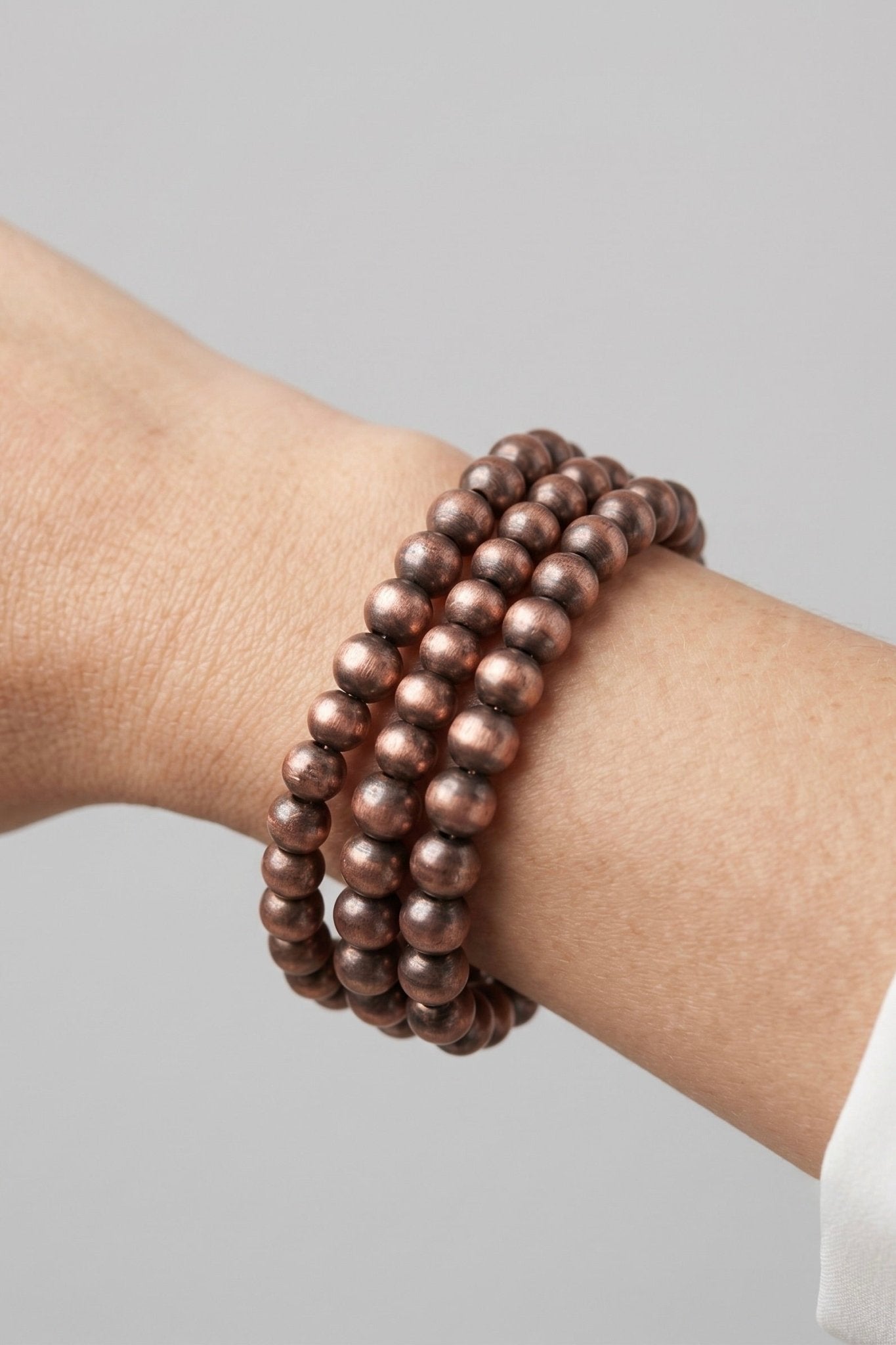 Copper beaded stretch bracelet stack featuring layered Navajo-inspired metallic beads, perfect for western outfits, rodeo style, country concerts, and everyday boutique jewelry.