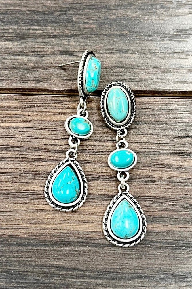 Turquoise stone drop earrings featuring three linked turquoise-look stones in antique silver settings. Western-inspired statement earrings perfect for rodeos, country concerts, cowgirl outfits, and everyday boutique styling.