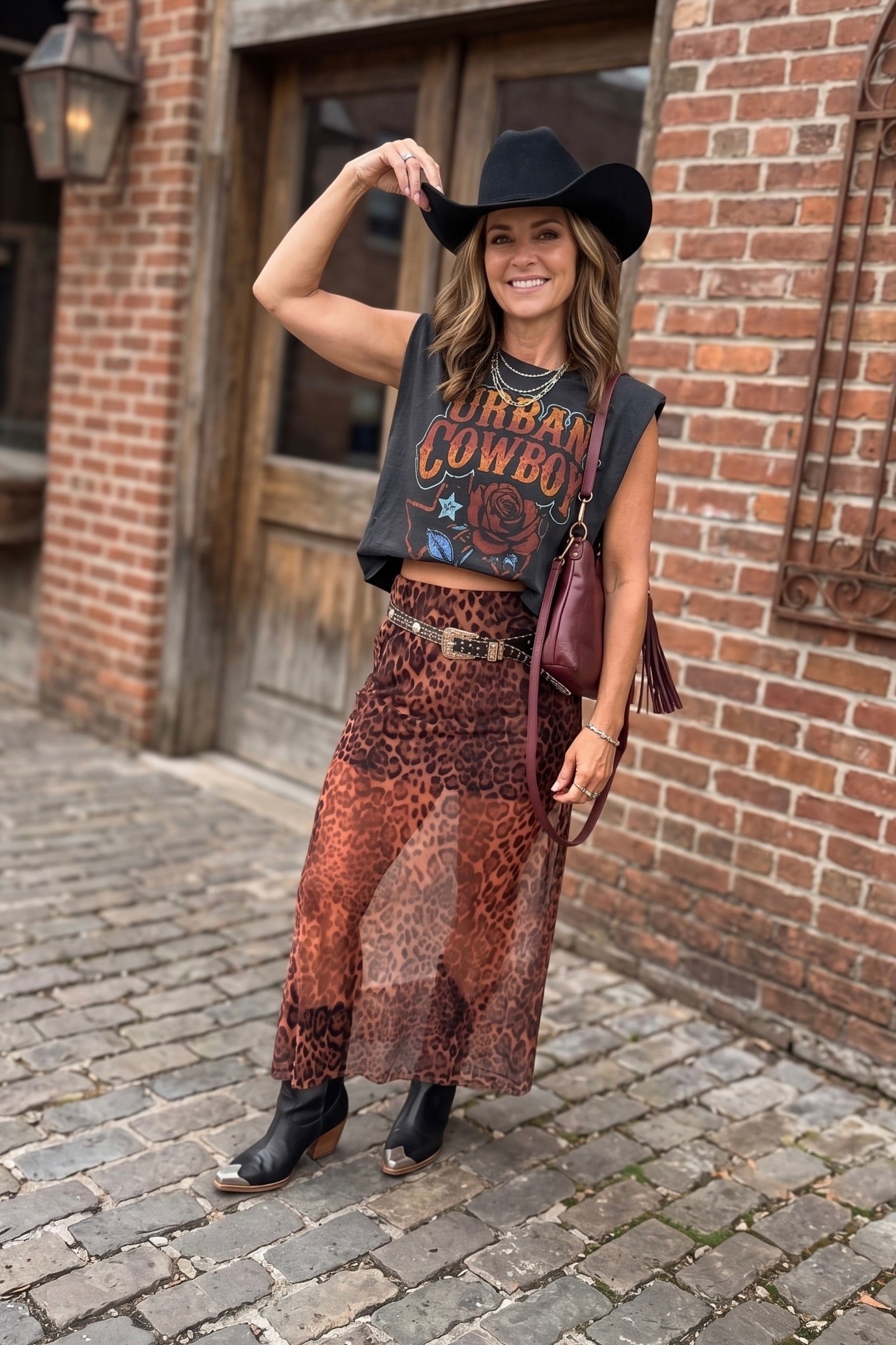 Black Urban Cowboy graphic muscle tee featuring a vintage western design with rose artwork, Fort Worth Texas lettering, and a relaxed boxy cropped fit.