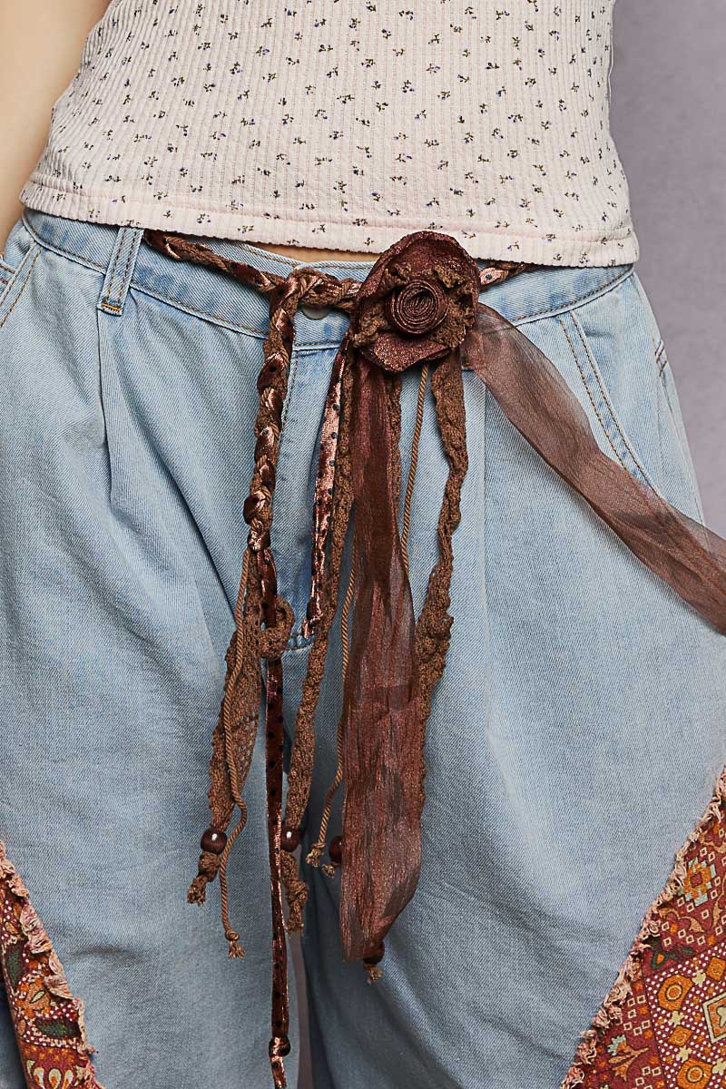 Fabric belt with artisan fabric, rosette accent, and multi layered ties. Knotted tassel detailing. Pol Brand