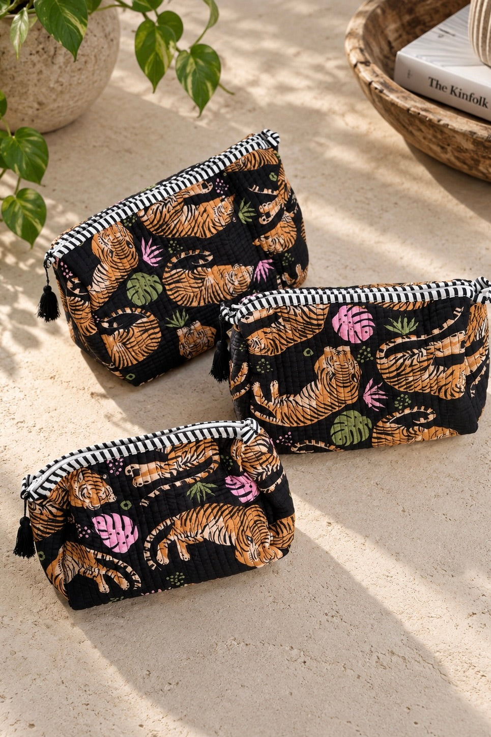 Black Roam If You Want To quilted tiger makeup bag set in three sizes with colorful tropical accents and black tassel zipper pulls.