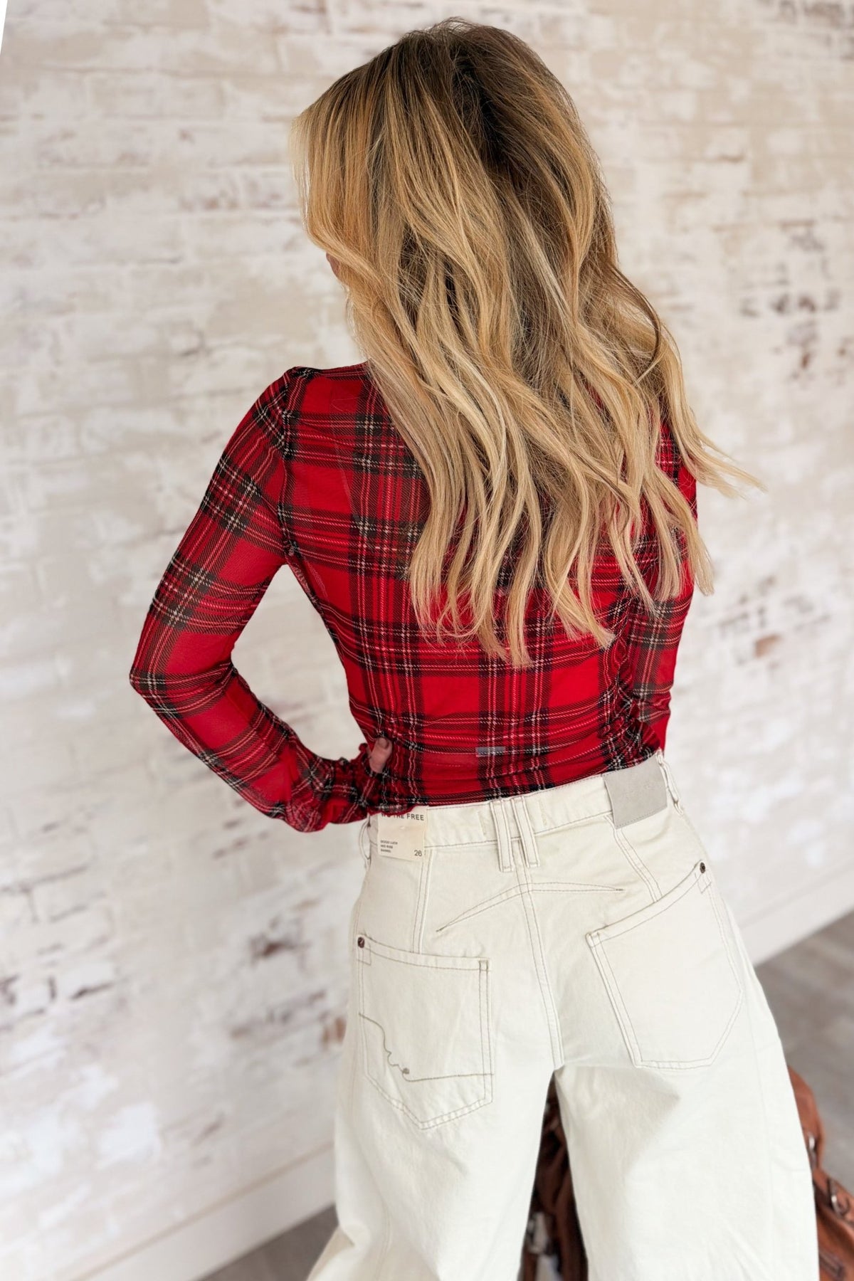 Women’s red plaid semi-sheer mesh long sleeve top featuring a fitted silhouette, high neckline, black and tan check pattern, and delicate frilled merrow lettuce-edge trim at the neckline, cuffs, and hem.