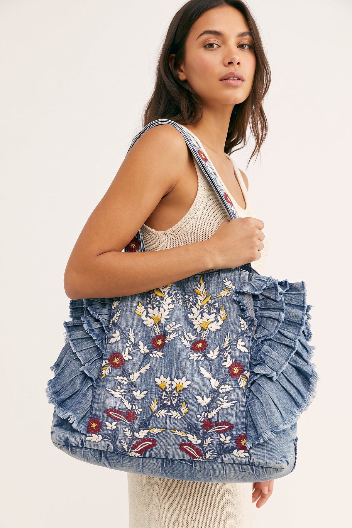 Cut From A Different Cloth vintage washed denim tote bag with colorful embroidered detailing, layered raw-edge ruffles, and embroidered shoulder straps.
