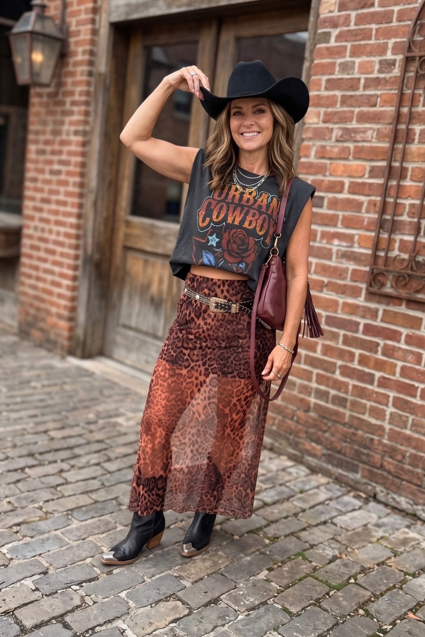 Black Urban Cowboy graphic muscle tee featuring a vintage western design with rose artwork, Fort Worth Texas lettering, and a relaxed boxy cropped fit.