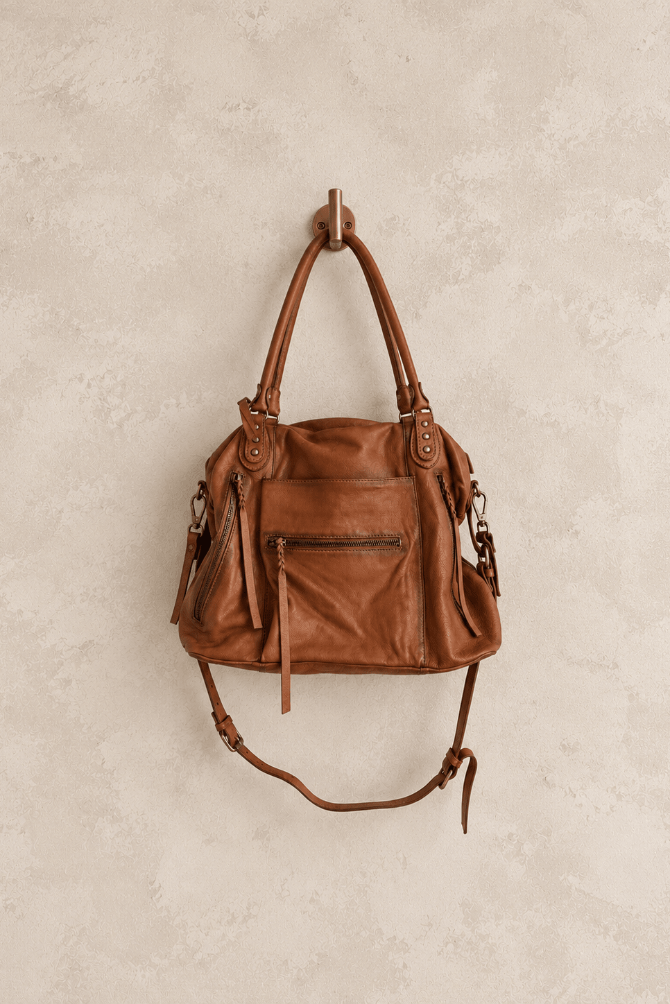 We The Free by Free People Emerson Tote Bag, a slouchy washed leather women’s carryall featuring a spacious interior, exterior zipper compartments, multiple pockets, buckle details, two top handles, adjustable detachable shoulder strap and zipper closure, available in Black, Saddle and Rusty Red.
