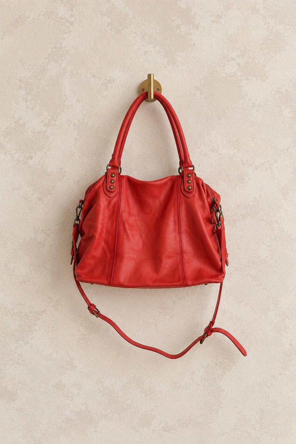 We The Free by Free People Emerson Tote Bag, a slouchy washed leather women’s carryall featuring a spacious interior, exterior zipper compartments, multiple pockets, buckle details, two top handles, adjustable detachable shoulder strap and zipper closure, available in Black, Saddle and Rusty Red.