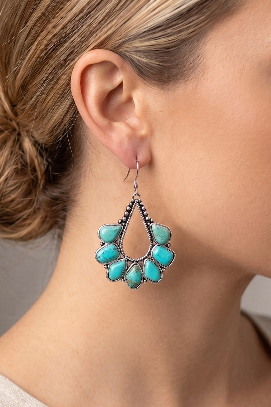 Navajo-style turquoise statement earrings featuring genuine turquoise stones in an open teardrop design with an antique silver finish.