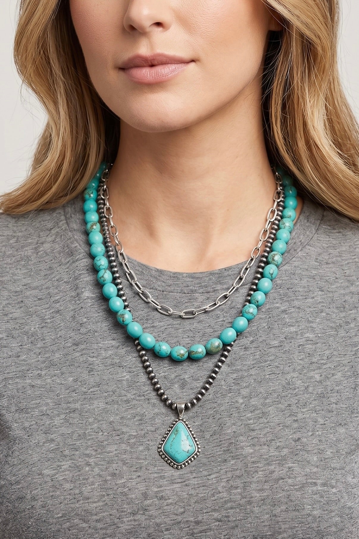 Three-strand western necklace featuring turquoise beads, Navajo-inspired pearls, a silver paperclip chain, and a turquoise pendant with an antique silver setting.