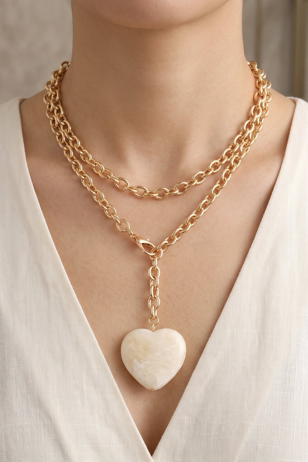 Pearly ivory oversized puffy acrylic heart pendant necklace with a long chunky gold-tone cable chain