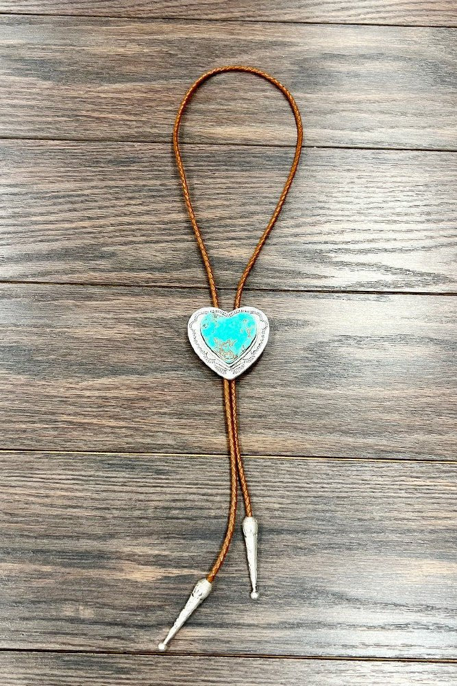 Love On The Range Heart Bolo necklace featuring a large turquoise heart pendant, adjustable leather cord, and antique silver western details for rodeo, country concert, and cowgirl outfits.