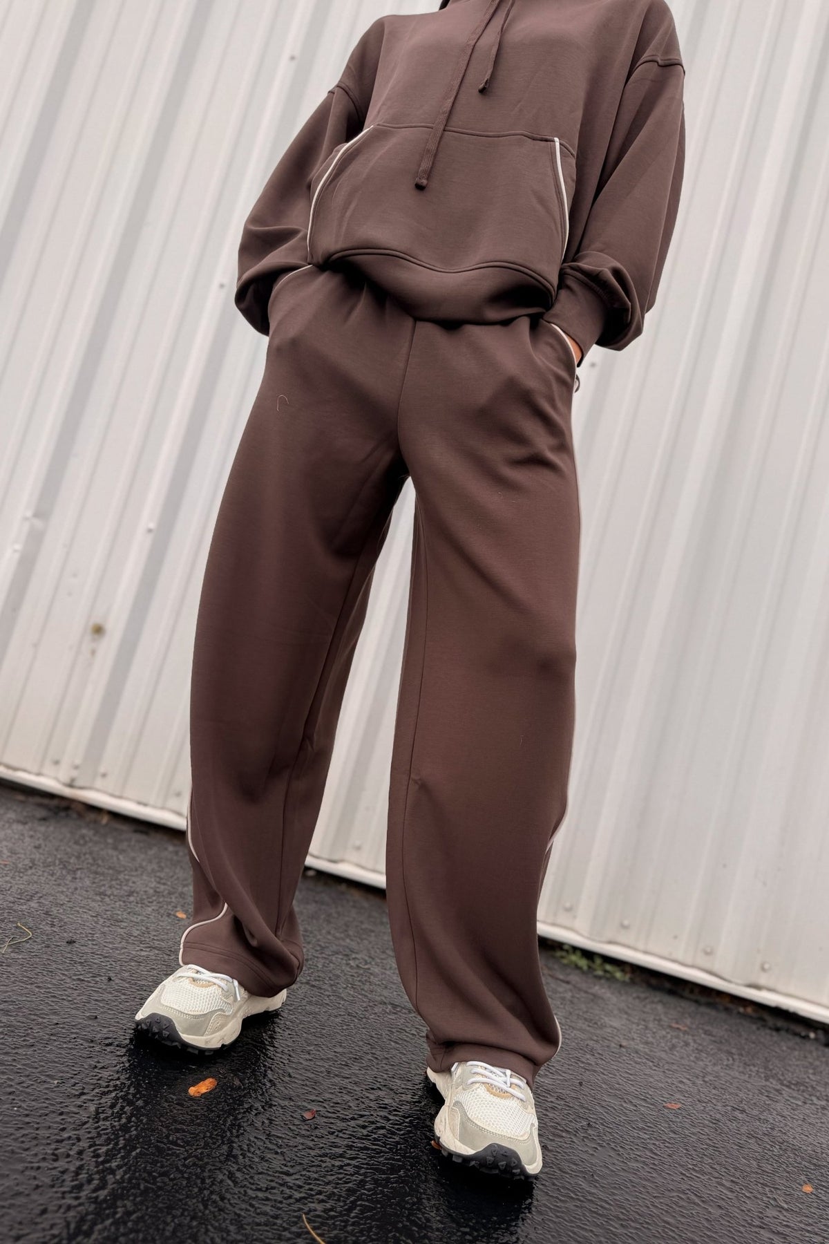 Women’s chocolate brown wide-leg sweatpants featuring a relaxed straight-leg silhouette, comfortable pull-on waistband, side pockets, and contrast ivory piping down the outer legs. Cozy lounge pants designed to coordinate with the matching chocolate brown hoodie, sold separately.