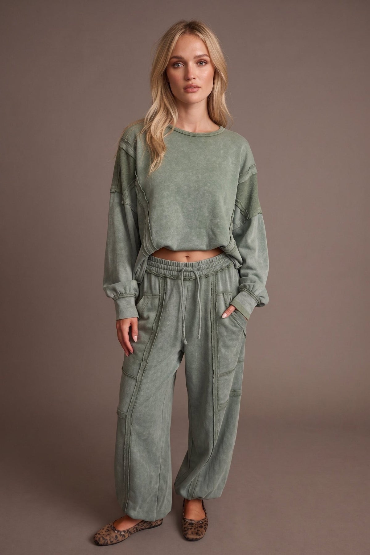 Women’s sage green mineral-washed two-piece lounge set featuring an oversized slightly cropped crewneck sweatshirt with exposed seam detailing and matching relaxed balloon jogger pants with an elastic drawstring waist, oversized patch pockets, exposed seams, and gathered ankles.