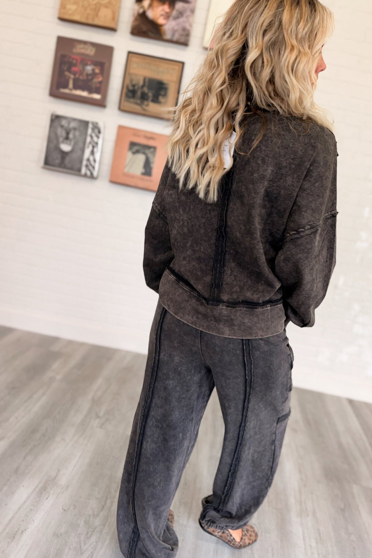 Women’s washed black mineral-washed two-piece lounge set featuring an oversized slightly cropped crewneck sweatshirt with exposed seam detailing and matching relaxed balloon jogger pants with an elastic drawstring waist, oversized patch pockets, exposed seams, and gathered ankles.
