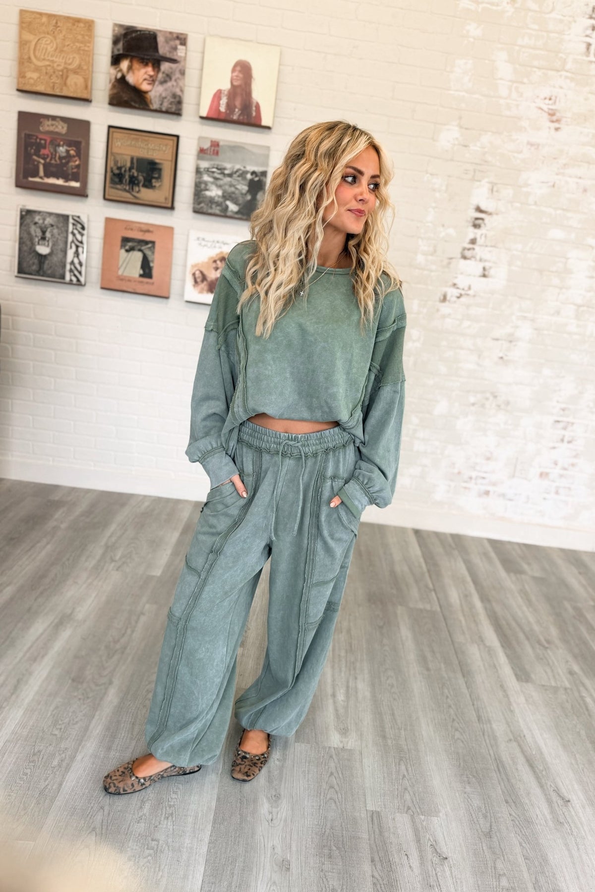 Women’s sage green mineral-washed two-piece lounge set featuring an oversized slightly cropped crewneck sweatshirt with exposed seam detailing and matching relaxed balloon jogger pants with an elastic drawstring waist, oversized patch pockets, exposed seams, and gathered ankles.