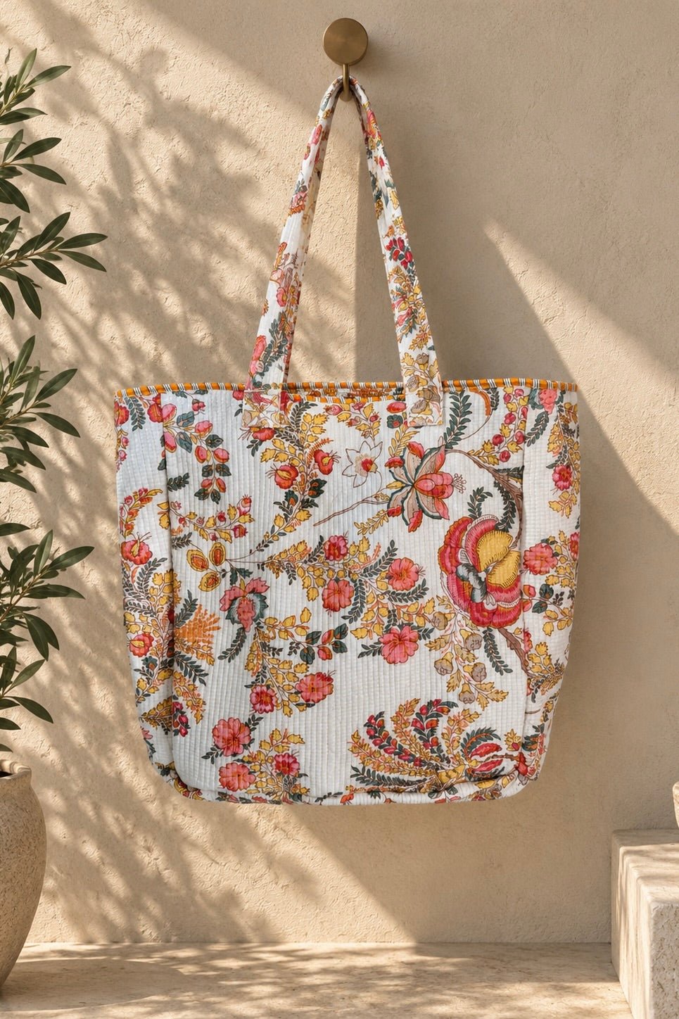 Oversized white quilted floral jumbo tote bag with colorful pink, green and yellow botanical print and double shoulder straps.