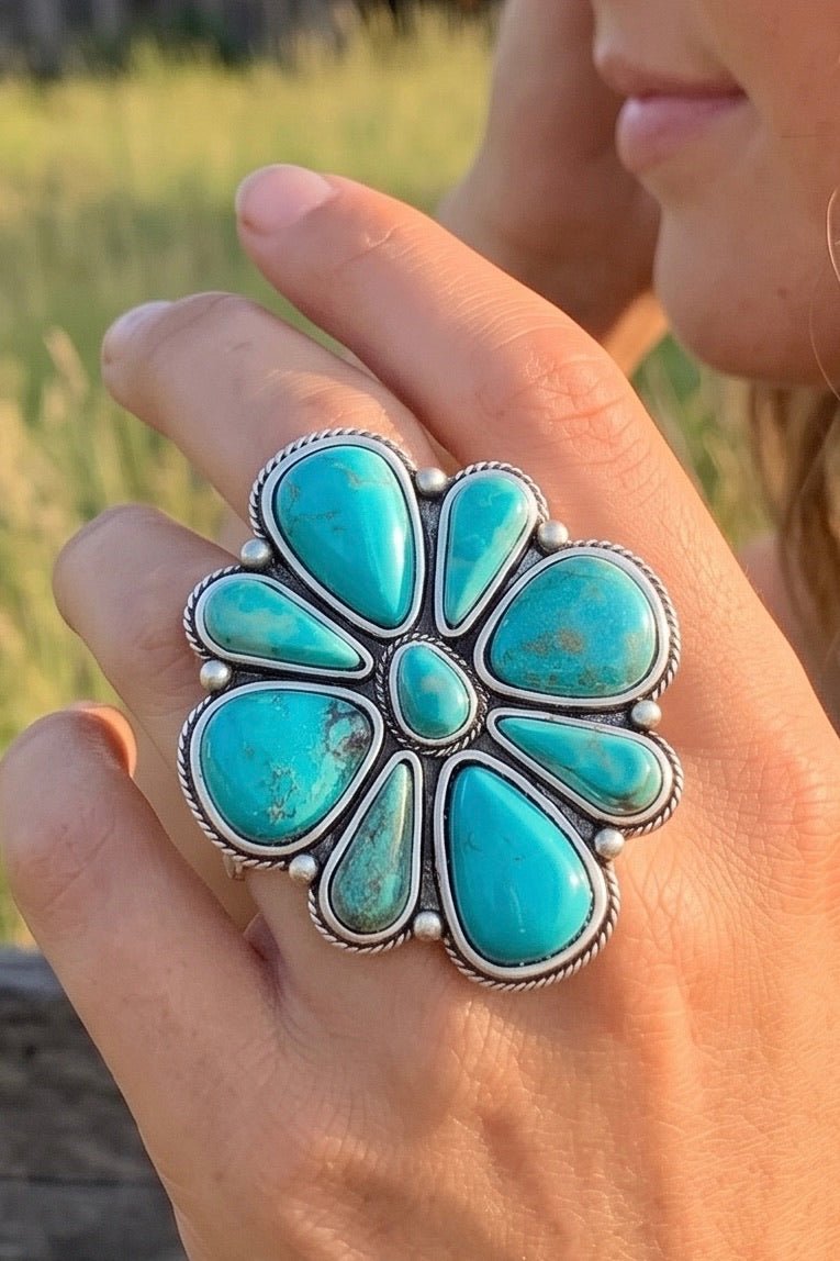Oversized turquoise statement ring with a Navajo-inspired floral design, natural turquoise stones, and an antique silver-plated setting on an adjustable band.