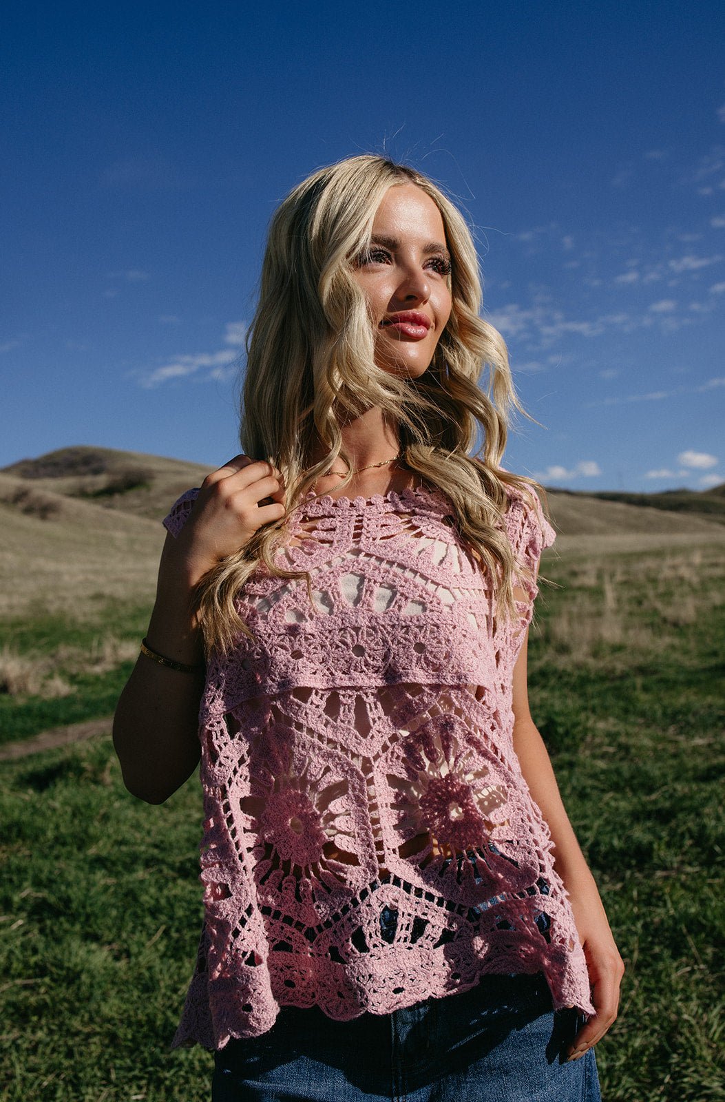 Pink crochet sleeveless top with intricate floral open-knit detail, styled for boho western outfits, summer festivals, and country concert looks.