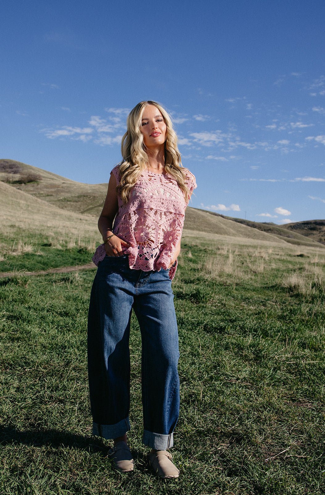 Pink crochet sleeveless top with intricate floral open-knit detail, styled for boho western outfits, summer festivals, and country concert looks.
